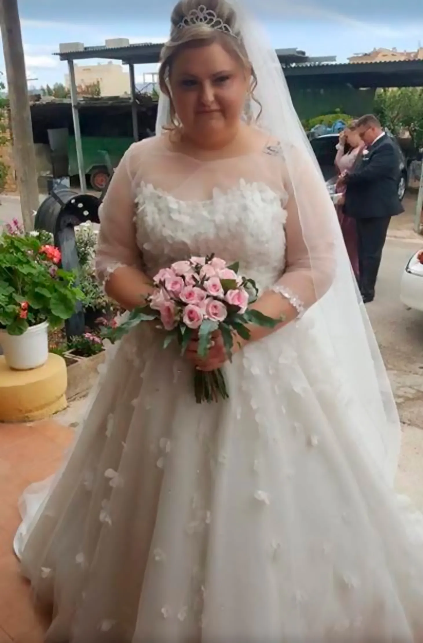 Novia con vestido de tul y flores bordadas el día de su boda